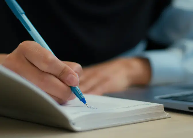 ノートにメモを取っている手元の写真