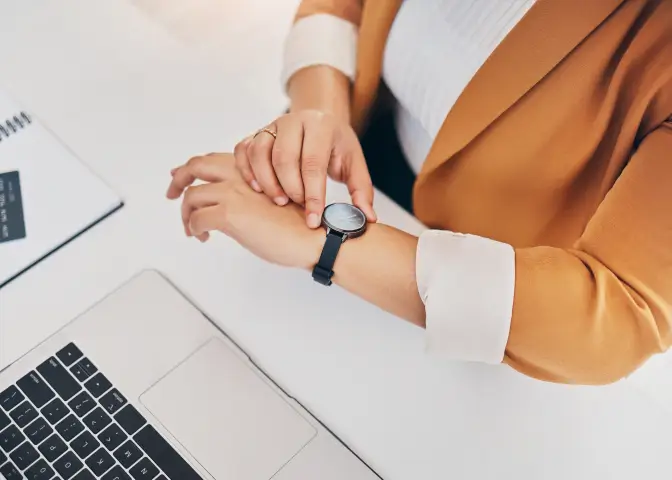 腕時計を確認する女性の写真